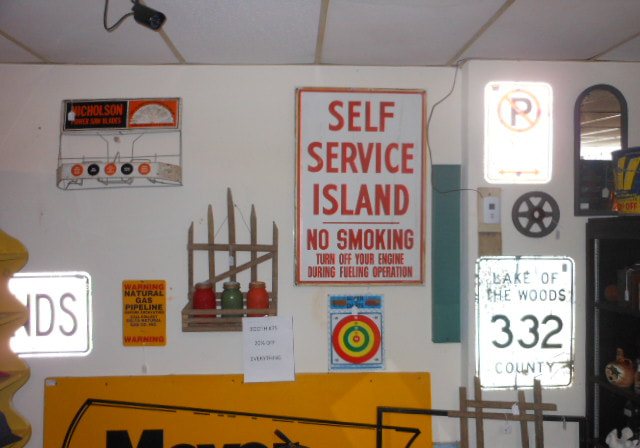 A wall of porcelain enamel road and gas station signs inside the shop