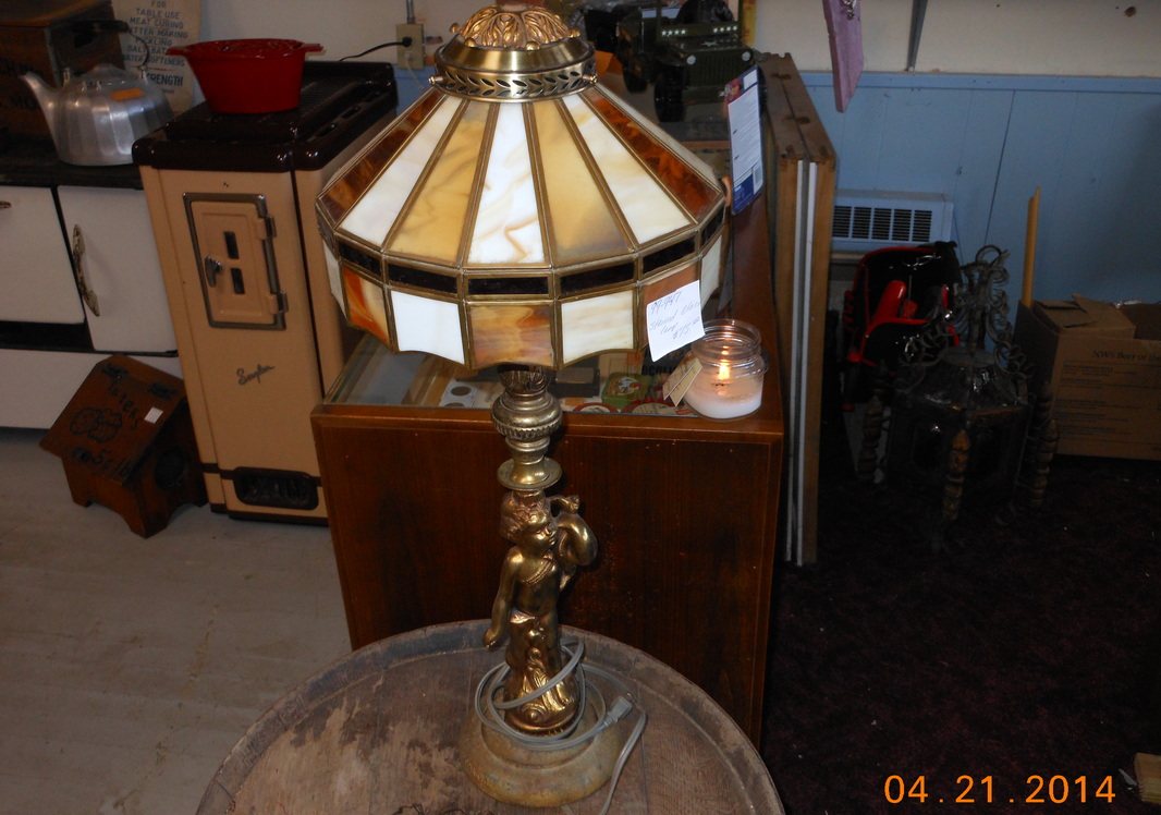 A stained glass table lamp with a brass base