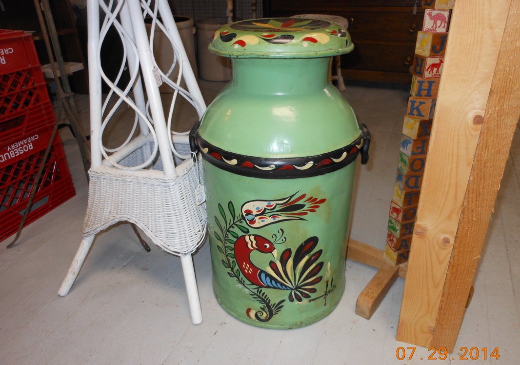 A painted milk can beside an oak chair and a gumball machine